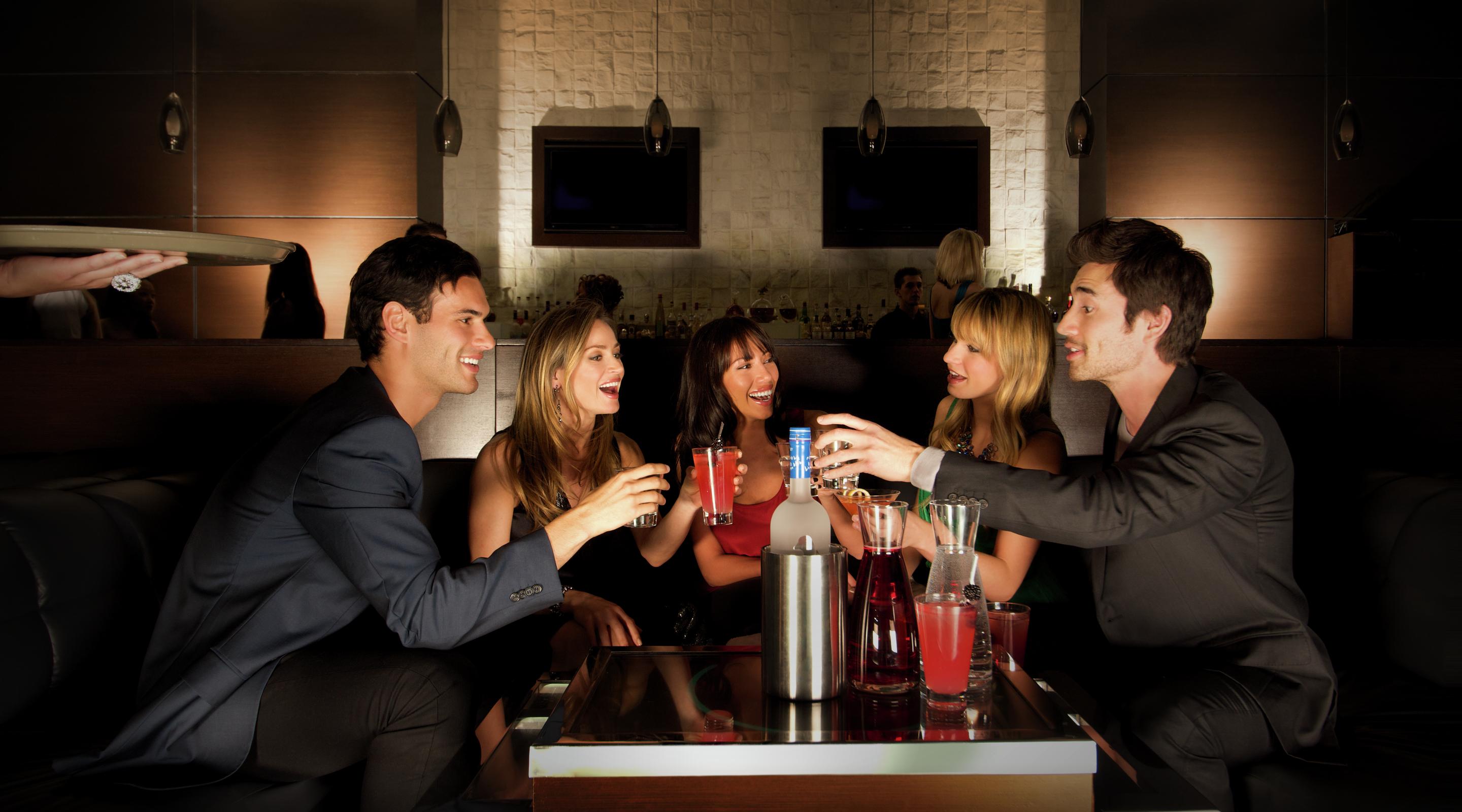 A group of friends share drinks and stories at Eyecandy.